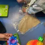 mfr rhone enfants manipulent sable paillettes et jouets sens